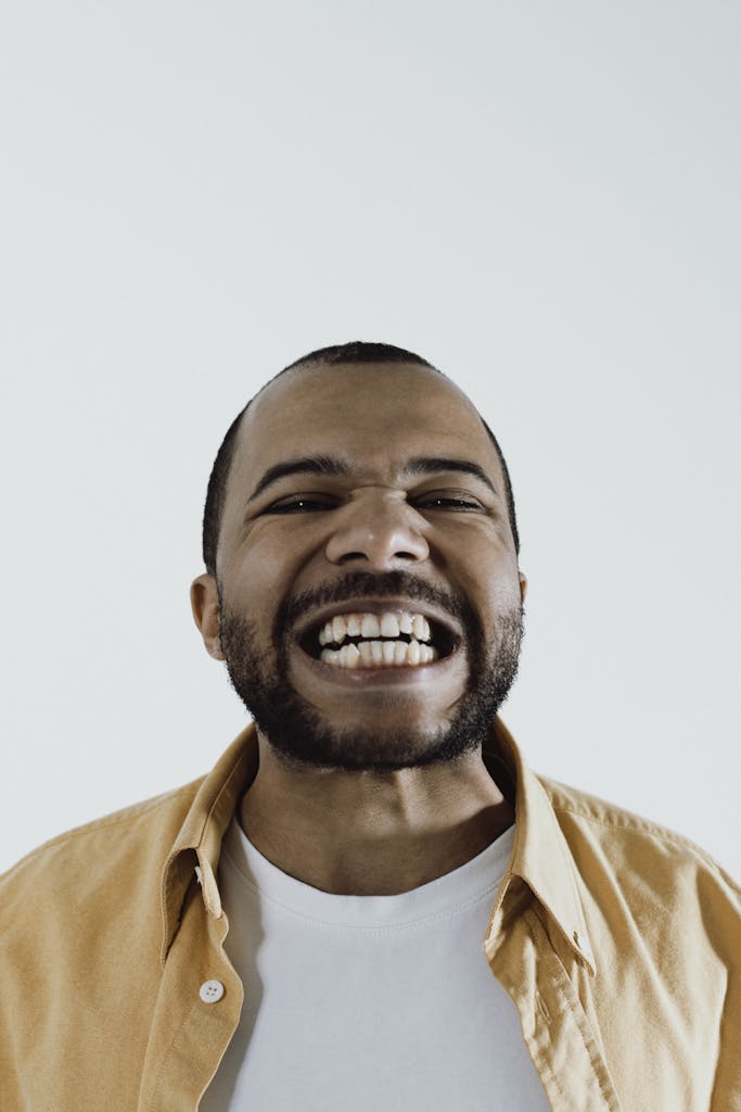 Close-up of an African American man with a big smile, showcasing joy and positivity.